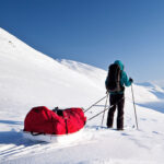 Person carrying a sled at the pole